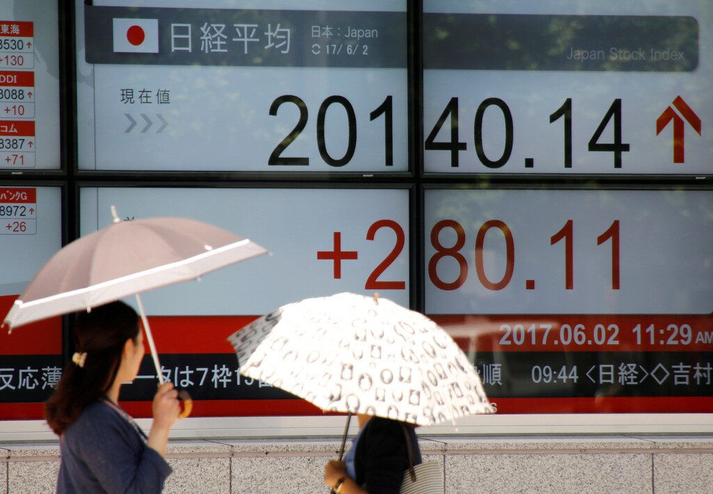 Women holding parasols, look at an electronic board showing Japan's Nikkei average outside a brokerage in Tokyo, Japan June 2, 2017. REUTERS/Toru Hanai TPX IMAGES OF THE DAY - RTX38MM6