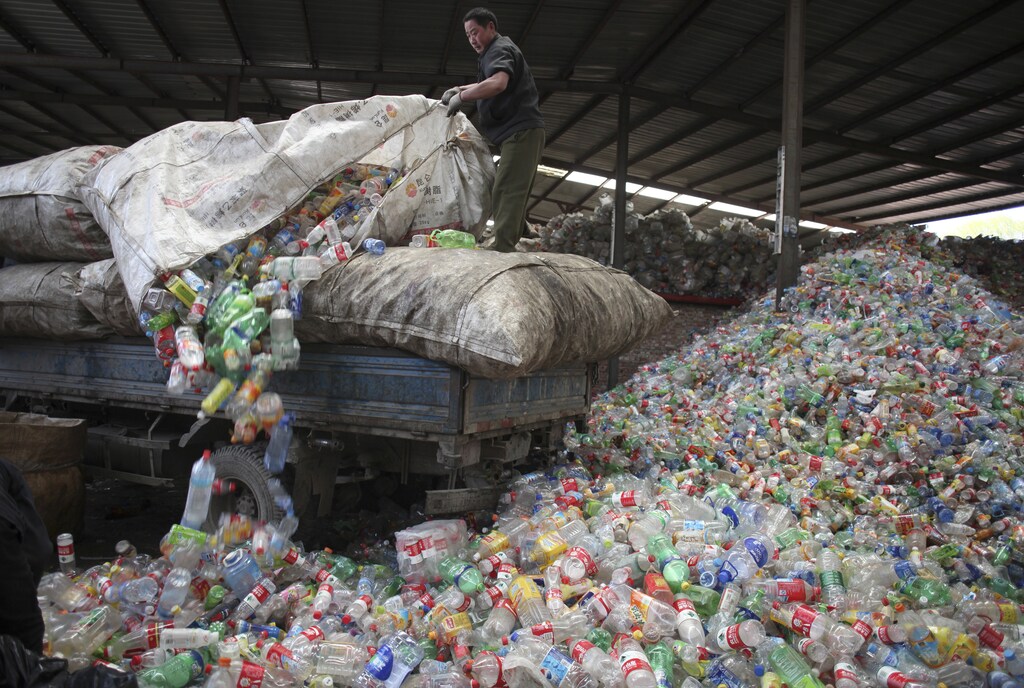 A worker unloads waste plastic bottles in the Changping district of Beijing.