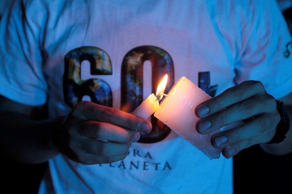 A participant lights a candle to form a "60+" sign during the Earth Hour environment campaign in Medellin, Colombia March 24, 2018. REUTERS/Fredy Builes - RC1FD0364300