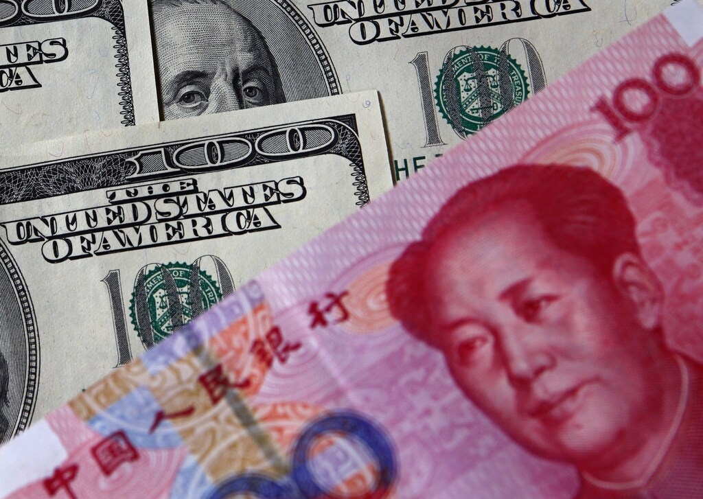 A 100 yuan banknote (bottom) is placed next to U.S. $100 banknotes in this picture illustration taken in Beijing, November 1, 2010. China will have to let the yuan rise further to reflect its robust economic growth amid growing fund inflows fanned by a loose U.S. monetary policy, an influential Chinese economist said in remarks published on Thursday. Picture taken November 1, 2010. REUTERS/Petar Kujundzic (CHINA - Tags: POLITICS BUSINESS) - RTXURR1