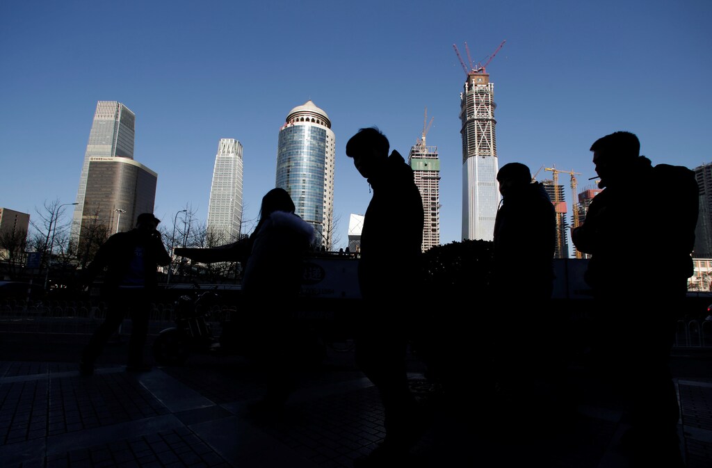 Pedestrians walk outside an office building in Beijing's central business area, China, January 20, 2017. REUTERS/Jason Lee - RTSWDTX