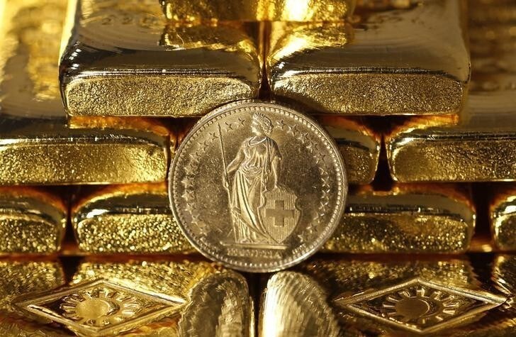 Gold bars and a Swiss Franc coin are seen in this illustration picture taken at the Austrian Gold and Silver Separating Plant 'Oegussa' in Vienna November 7, 2014. A vote in favour of Switzerland boosting its gold reserves would be disastrous for the country, the chairman of the Swiss central bank said in a newspaper interview published on Thursday. The "Save our Swiss gold" proposal, spearheaded by the right-wing Swiss People's Party (SVP), aims to ban the central bank from offloading its reserves and oblige it to hold at least 20 percent of its assets in gold. The referendum is scheduled for November 30. The SVP argues it would secure a stable Swiss franc. Picture taken November 7, 2014. REUTERS/Leonhard Foeger (AUSTRIA)