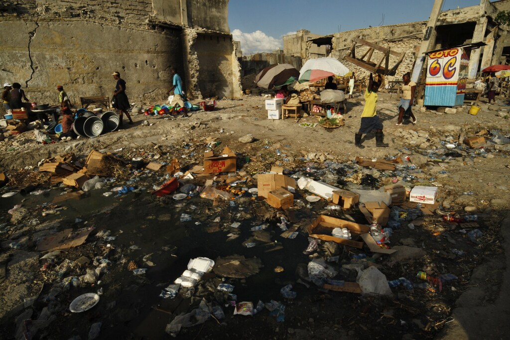 People walk past stalls in downtown Port-au-Prince March 21, 2011. The United Nations urged Haitians on Monday to calmly wait for the first results due next week of Sunday's presidential run-off, saying the earthquake-battered nation's democratic future was at stake. REUTERS/Eduardo Munoz