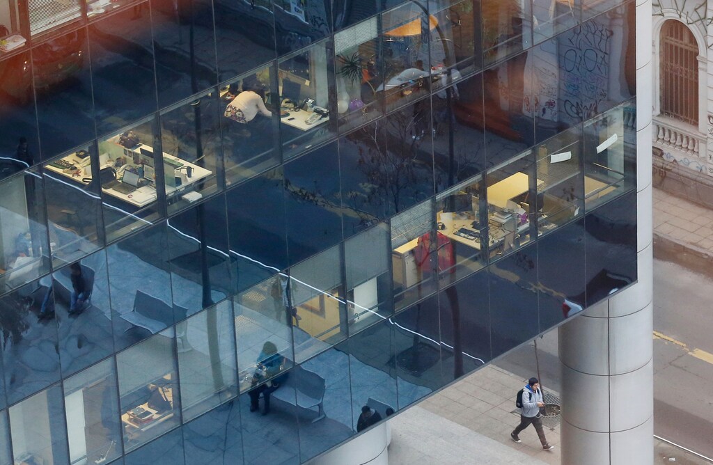 A building is pictured with employees in their offices and reflections in their windows at Santiago town, Chile, July 13, 2017. REUTERS/Rodrigo Garrido - RC122793C490