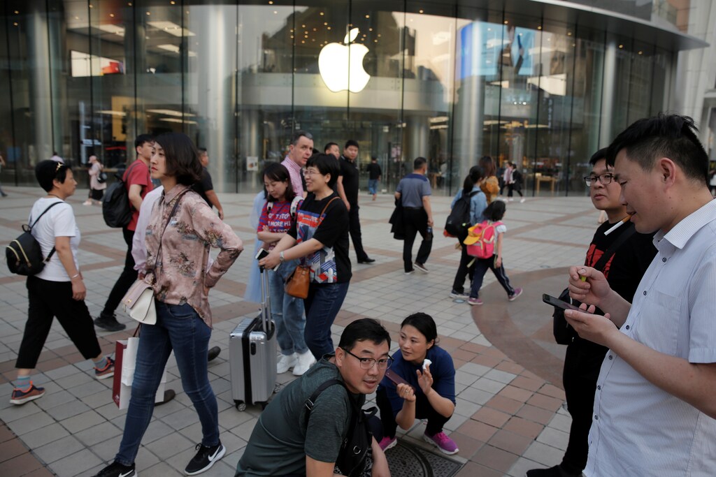 People walk past an Apple store in Wangfujing shopping street in Beijing, China May 15, 2019. REUTERS/Thomas Peter - RC178258CE60