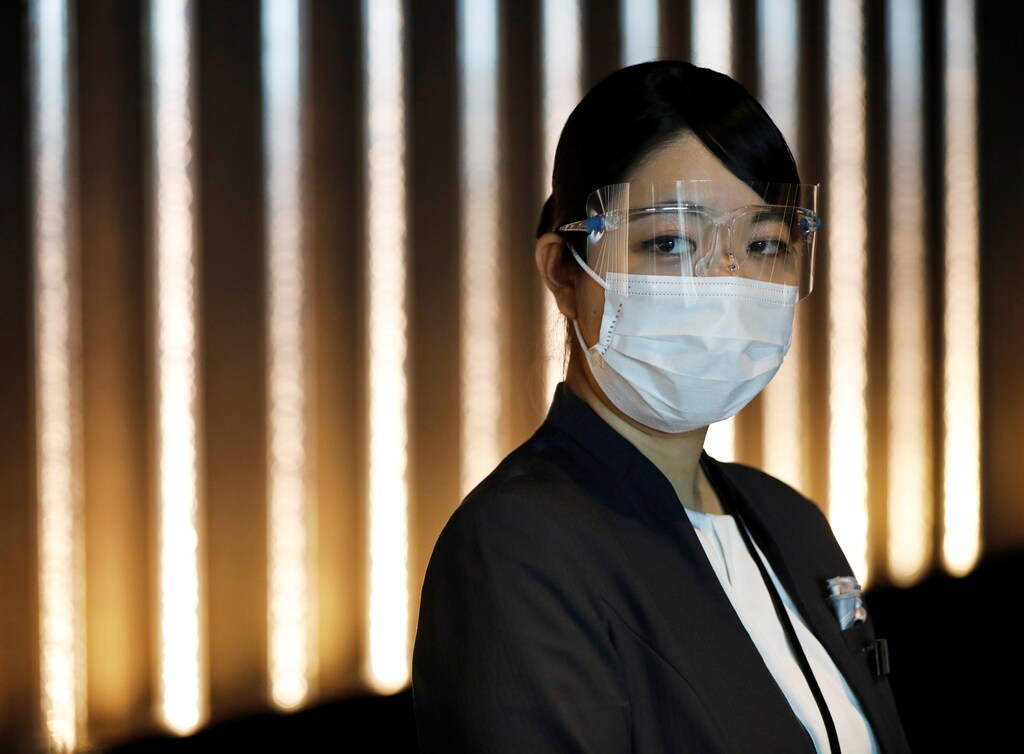 A hotel worker wears a protective mask and goggles at the reception desk of Mitsui Garden Hotel Nihonbashi Premier during the spread of the coronavirus disease (COVID-19) in Tokyo, Japan June 26, 2020.