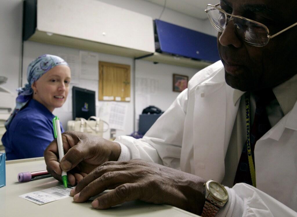Phlebotomist Colliston Rose labels a blood sample taken from cancer patient Deborah Charles during a weekly test to monitor blood counts at Georgetown University Hospital's Lombardi Cancer Center in Washington May 23, 2007. Since Charles, a journalist for Reuters, was diagnosed with breast cancer in November 2006, she has had to back away from actively covering the news and has had three operations, four rounds of chemotherapy and has been visiting the hospital at least once a week for appointments and treatment. Photo taken May 23, 2007. To match feature WITNESS-CANCER/DISCOVERY REUTERS/Jim Bourg (UNITED STATES) - GM1DVKLYUVAA