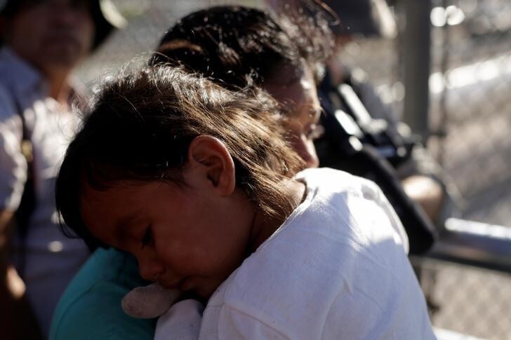 A migrant family from Mexico, fleeing from violence, wait to enter the United States to meet officers of the U.S. Customs and Border Protection to apply for asylum at Paso del Norte international border crossing bridge in Ciudad Juarez June 20, 2018. REUTERS/Jose Luis Gonzalez