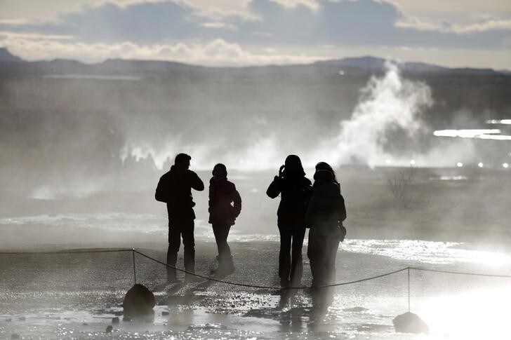 People walk in the mist of sulphuric fumes at the site of the Great Geysir in southwestern Iceland February 15, 2013. REUTERS/Stoyan Nenov (ICELAND - Tags: TRAVEL)