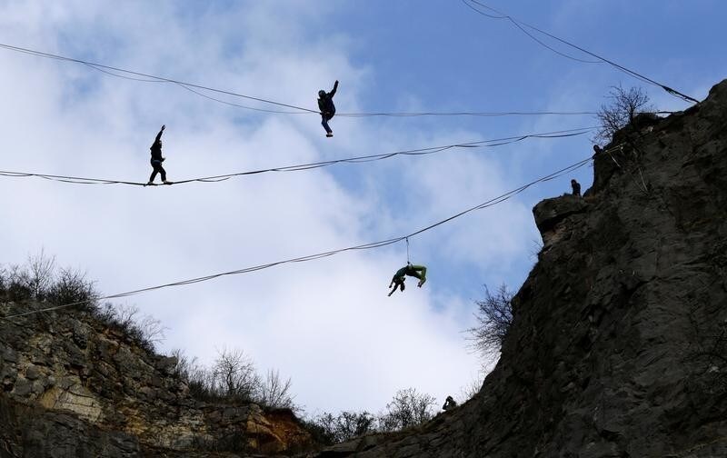 Participants balance on lines during a highline event near the town of Beroun, Czech Republic March 24, 2018.