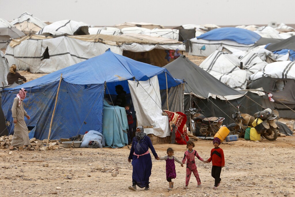 Syrian refugees stuck between the Jordanian and Syrian borders waiting to cross into Jordan, walk at a camp, after a group of them crossed into Jordanian territory, near the town of Ruwaished, at the Hadalat area, east of the capital Amman, May 4, 2016. REUTERS/Muhammad Hamed - RTX2CVM3