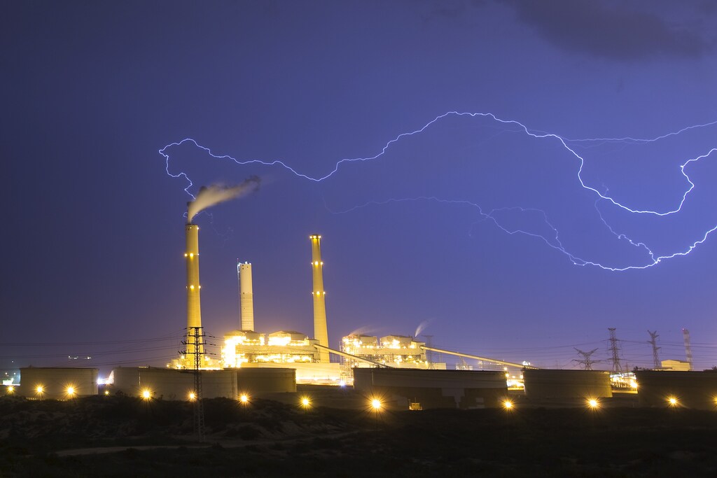 Lightning strikes over a power station during a storm in the city of Ashkelon October 28, 2015.