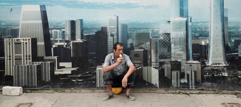 A worker eats ice cream as he rests outside a construction site in Beijing's central business district, China August 16, 2017. REUTERS/Jason Lee - RC1B784D2810