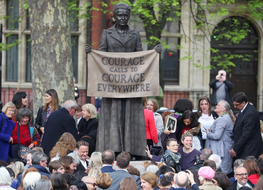 People attending the official unveiling gather around the statue of suffragist Millicent Fawcett on Parliament Square