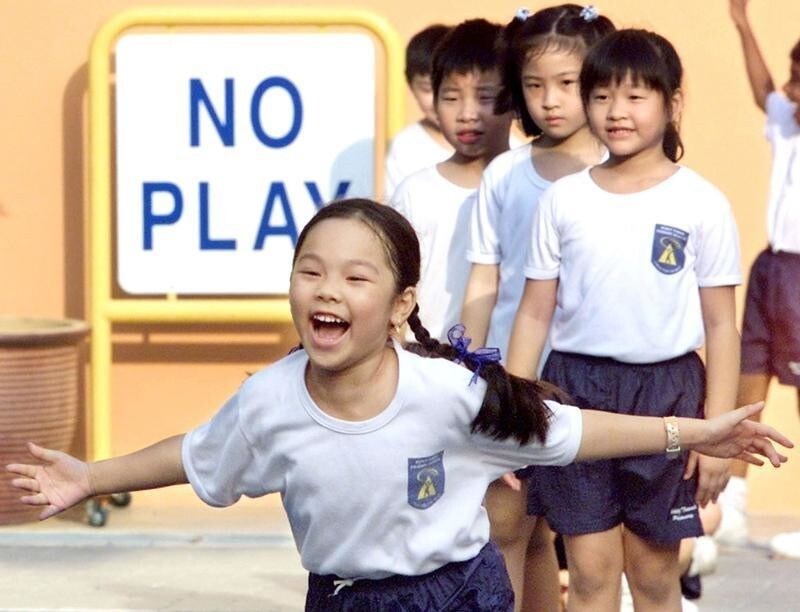 A Singapore student participates in a foot race while others wait theirturn in a school playground August 8, 2002. A recent survey by localnewspaper The Straits Times found that schoolchildren in the islandrepublic have about two hours of free time a day amid schedules packedwith homework, supplementary classes and co-curricular and enrichmentactivities.