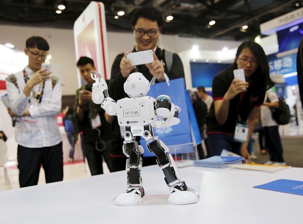 Visitors take pictures of humanoid intelligent robot Alpha developed by UBTECH at the Global Mobile Internet Conference (GMIC) 2015 in Beijing, China, April 28, 2015.
