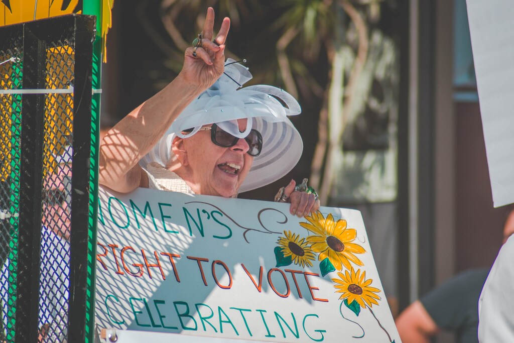 image of a woman holding up a sign celebrating women's right to vote