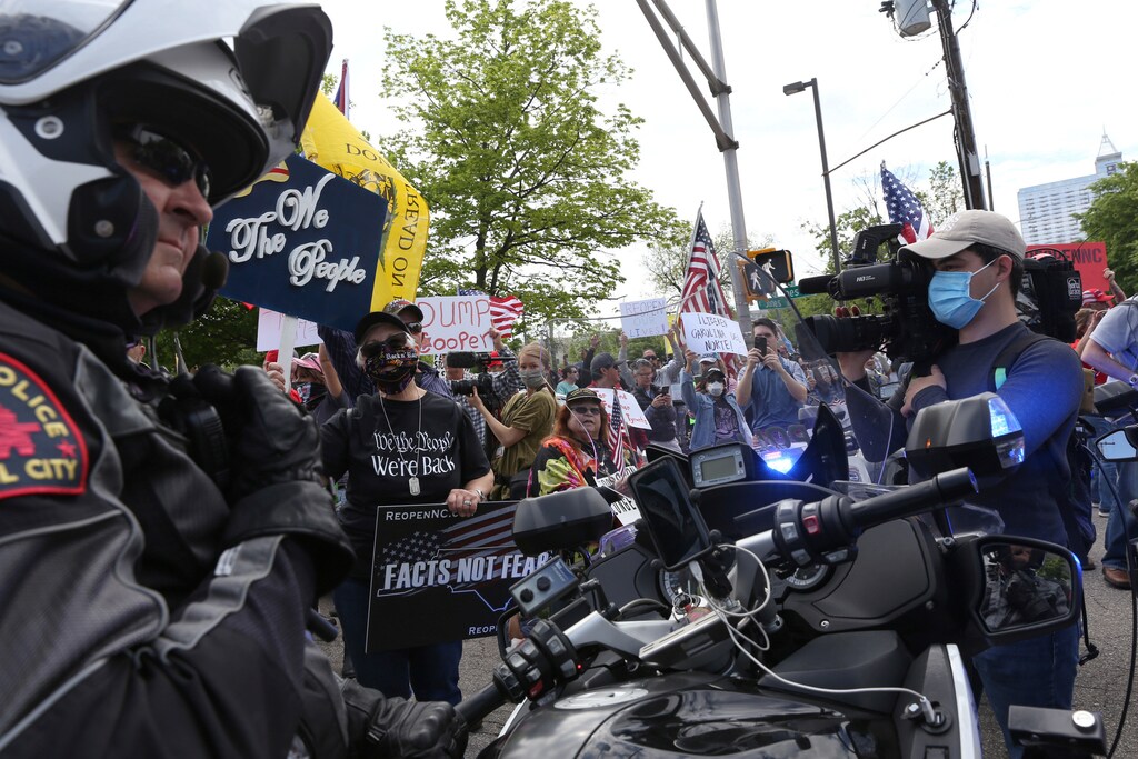 Police watch as protesters gather for a ReOpenNC rally against the state's shut down to prevent the spread of coronavirus disease (COVID-19) in Raleigh, North Carolina, U.S., April 21, 2020.