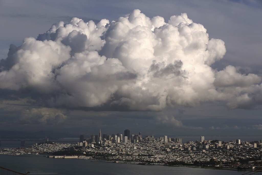 A large cloud gathers over the skyline of San Francisco, California December 12, 2014. A major storm pummeled California and the Pacific Northwest with heavy rain and high winds on Thursday, killing one man, knocking out power to tens of thousands of homes, disrupting flights and prompting schools to close. REUTERS/Robert Galbraith (UNITED STATES - Tags: ENVIRONMENT CITYSCAPE TPX IMAGES OF THE DAY) - RTR4HU40