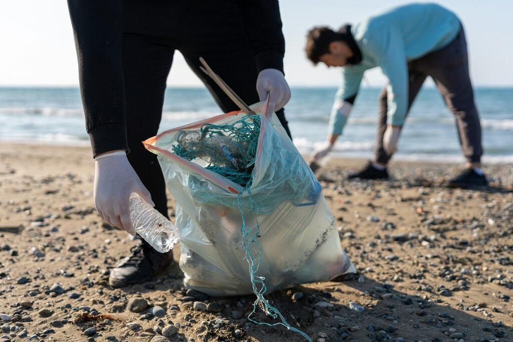 A man collects plastic from a beach: Young people are addressing the plastics challenge with circular solutions
