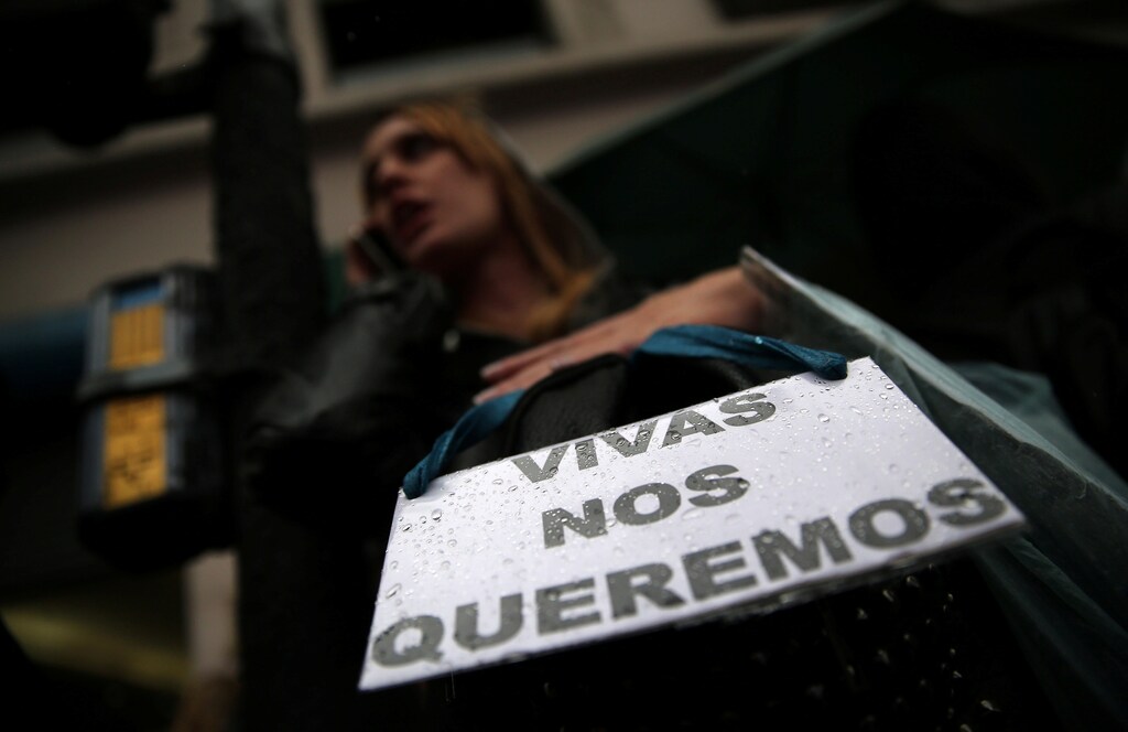 A woman talks on her cell phone as she carries a sign that reads "We want us alive" during a demonstration to demand policies to prevent gender-related violence, Argentina, October 19, 2016. REUTERS/Marcos Brindicci - RTX2PLCI