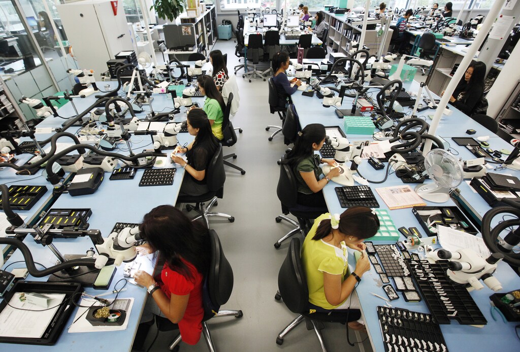 Employees work in the production facility of Phonak hearing devices of Swiss hearing aid maker Sonova at the company's headquarters in the village of Staefa east of Zurich September 5, 2012. REUTERS/Michael Buholzer (SWITZERLAND - Tags: BUSINESS EMPLOYMENT HEALTH) - BM2E89510QJ01