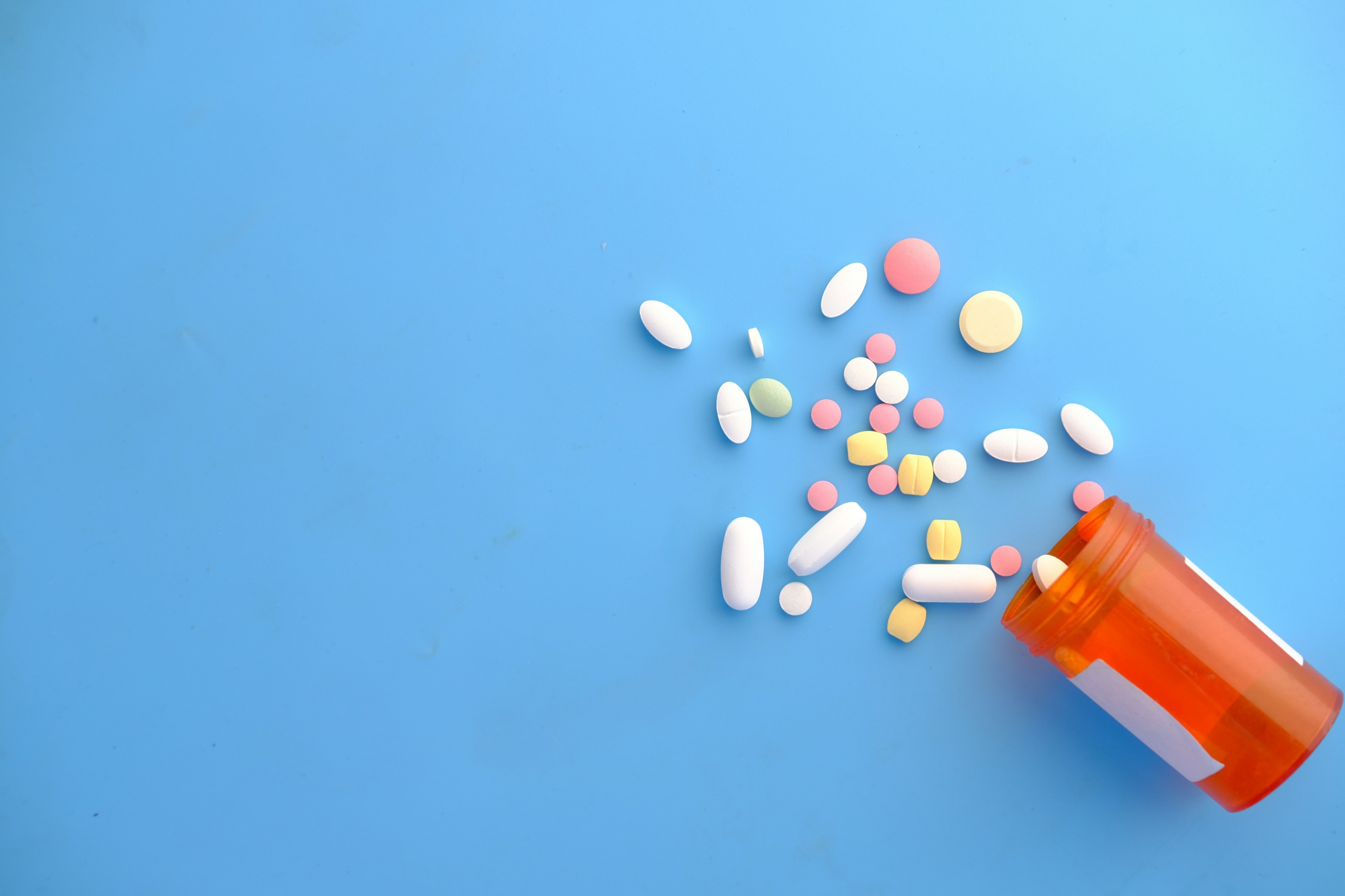 colourful pills on a blue surface - antimicrobial resistance