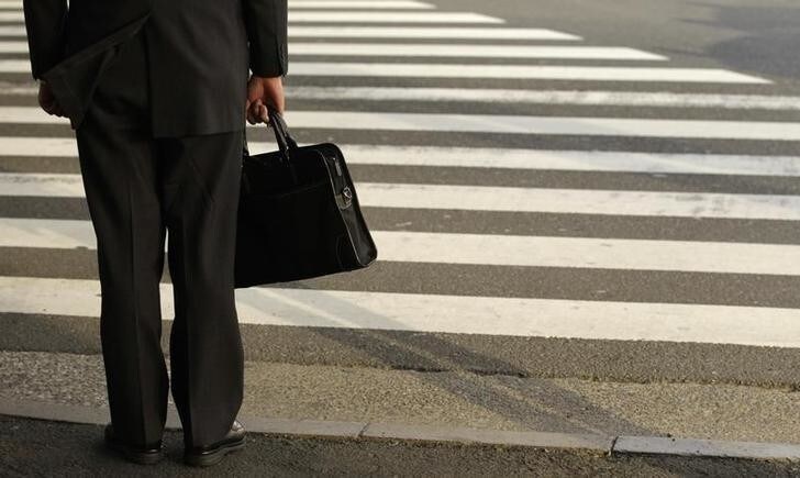 A businessman waits to cross a street in Tokyo April 4, 2011. Japanese big manufacturers expect conditions to worsen significantly in the next three months, responses to a Bank of Japan survey collected after the March 11 earthquake showed on Monday. REUTERS/Yuriko Nakao (JAPAN - Tags: EMPLOYMENT BUSINESS POLITICS)