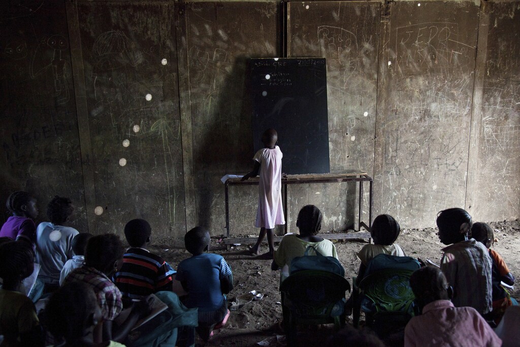 A girl copies her lesson from the blackboard at the Pibor Primary School in Pibor, South Sudan, June 25, 2012. For decades, Sudan's southerners fought the country's predominately Arab rulers in the north. More than two million people died before the fighting ended in a peace deal in 2005. In a referendum promised by the pact, 99 percent of the southerners chose to secede, and on July 9, 2011, the flag of South Sudan was raised over Juba, the rickety new capital. Picture taken June 25, 2012. To match Special Report SOUTH-SUDAN/GOVERNED REUTERS/Adriane Ohanesian (SOUTH SUDAN - Tags: ANNIVERSARY POLITICS EDUCATION) - GM1E8790RO201
