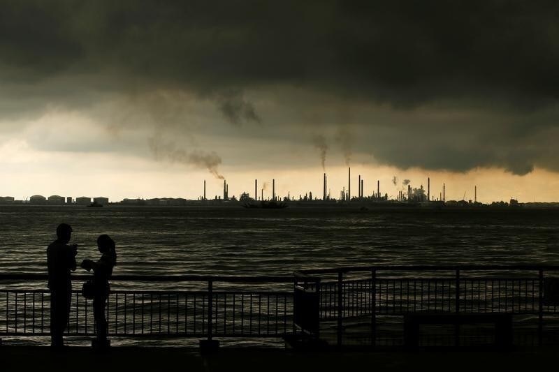 Storm clouds gather over Shell's Pulau Bukom oil refinery in Singapore December 17, 2014.