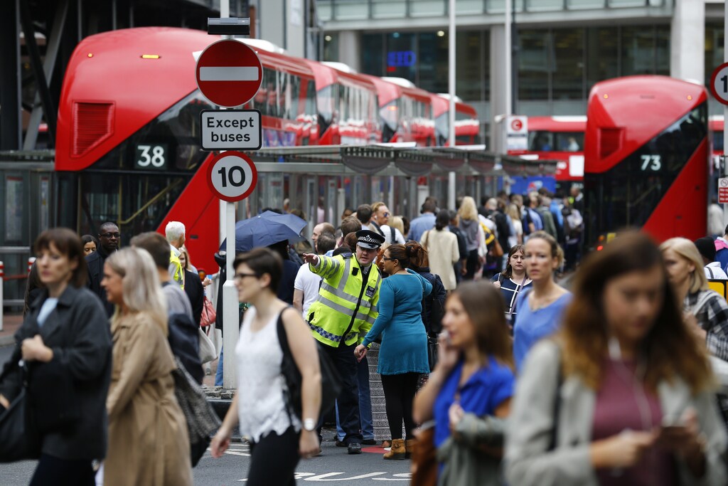 A police officer directs a woman as commuters wait for buses at Victoria Station in London, Britain August 6, 2015. REUTERS/Darren Staples