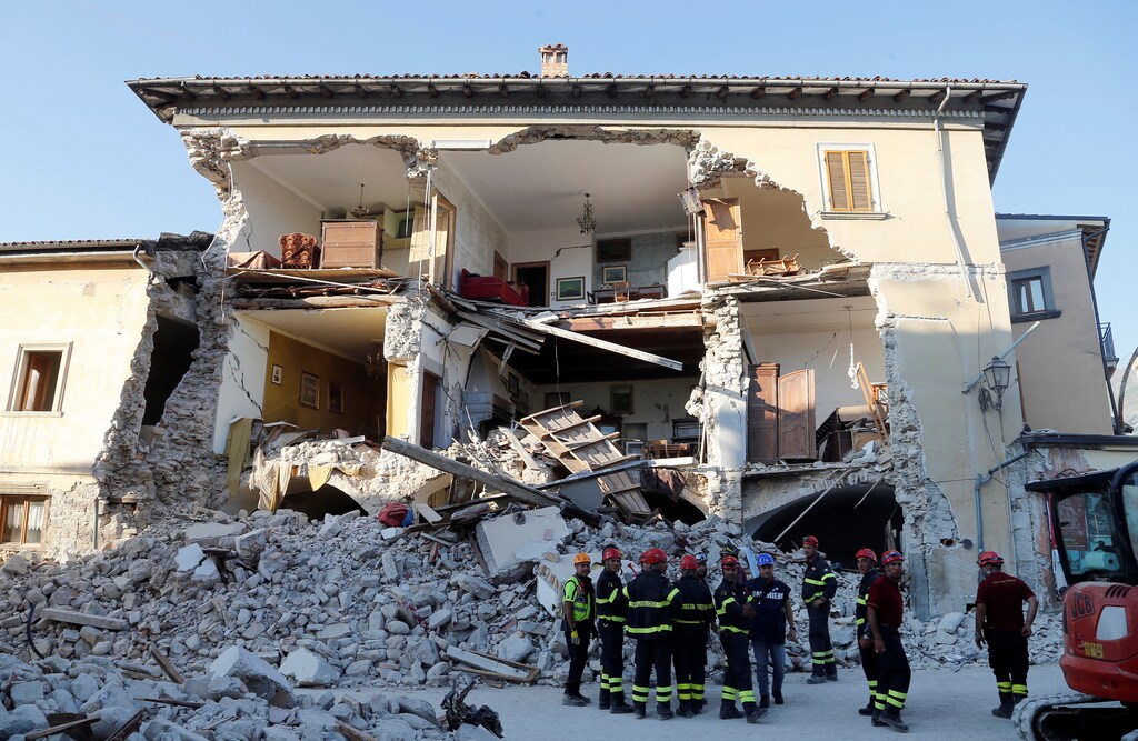 Firefighters stand next to a collapsed house following an earthquake in Amatrice, central Italy, August 27, 2016. REUTERS/Ciro De Luca - RTX2NABM