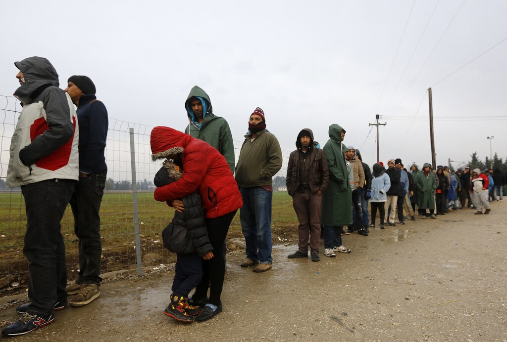 EDITORIAL USE ONLY - NO COMMERCIAL OR BOOK SALES. A stranded Iranian woman embraces her daughter as hundreds of migrants line up during food distribution at the Greek-Macedonian border, near the Greek village of Idomeni November 25, 2015. European countries are stretched to their limits in the refugee crisis and cannot take in any more new arrivals, the French Prime Minister was quoted as saying in a German newspaper on Wednesday. REUTERS/Yannis Behrakis
