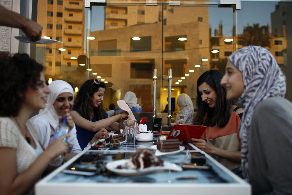 Palestinian women sit together at a newly opened upscale Italian cafe in the West Bank city of Ramallah July 3, 2012.