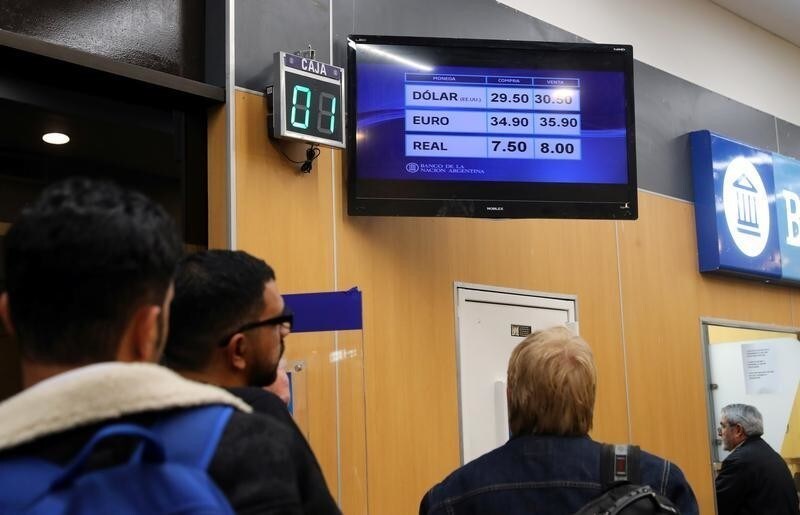 People line up to exchange currency outside a bank at Buenos Aires' metropolitan airport, Argentina August 13, 2018.