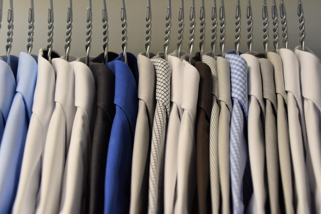 a side view of a row of hangers with shirts on