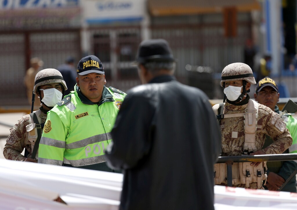 Un hombre habla con un policía en la frontera entre Perú y Bolivia después del anuncio del gobierno peruano del cierre de la frontera en un intento de frenar la propagación del nuevo coronavirus (COVID-19), en Desaguadero, Bolivia, el 17 de marzo de 2020.