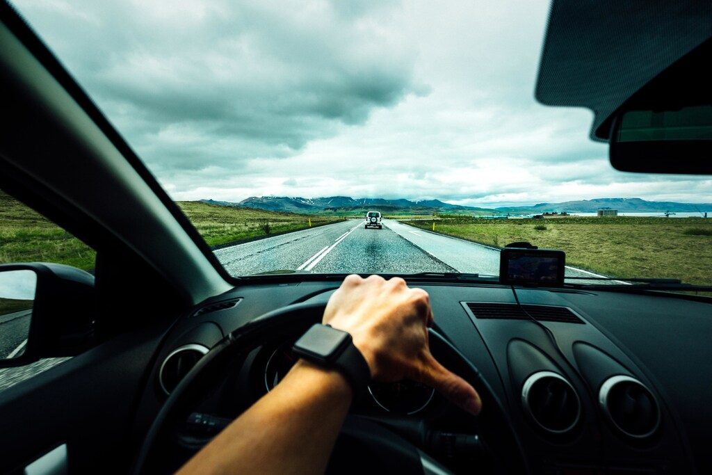A person in their car driving along a road.