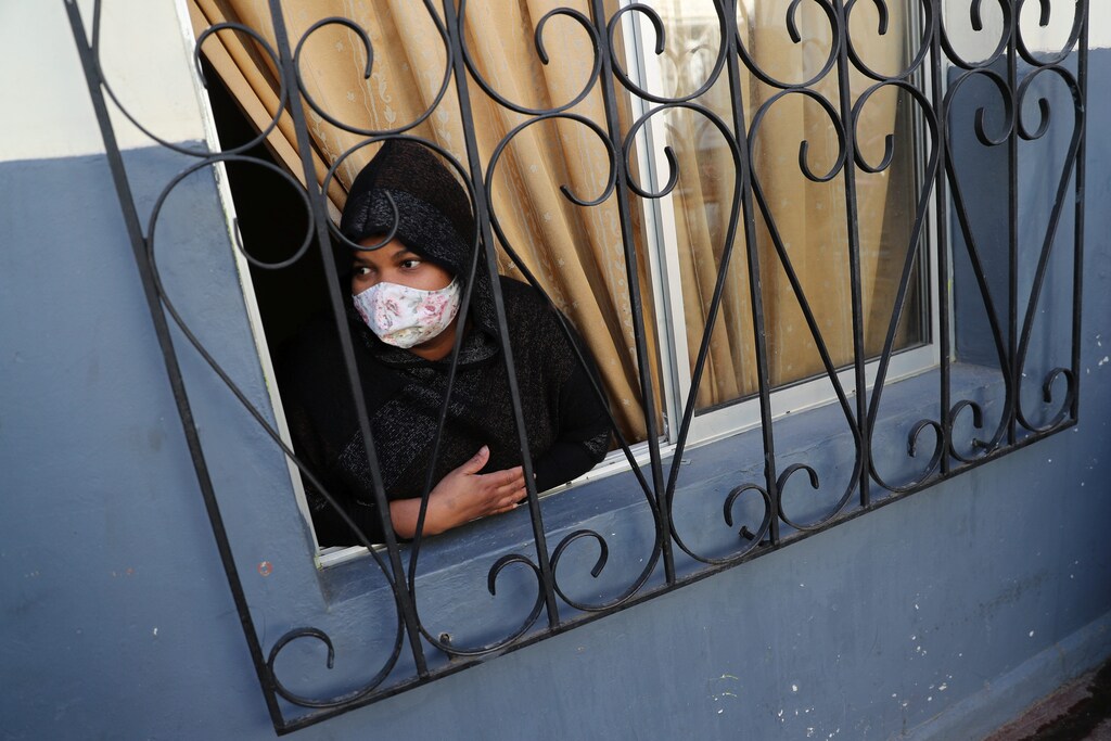Un inmigrante peruano mira desde su ventana a un barrio pobre, durante una cuarentena general en medio de la propagación de la enfermedad coronavirus (COVID-19) en Santiago de Chile el 22 de mayo de 2020.