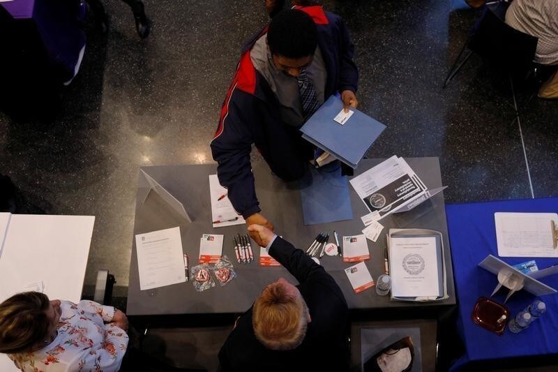 Job seeker Tony Harris (top) shakes hands with a representative from Verizon at a City of Boston Neighborhood Career Fair in Boston, Massachusetts, U.S., May 1, 2017. REUTERS/Brian Snyder - RC14442C6AE0