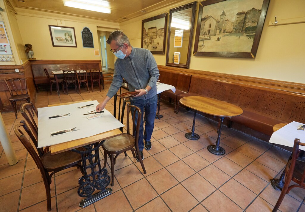 Gerald Bongioanni sets a table on the reopening day of the Cafe du Soleil as Switzerland eases the lockdown measures during the coronavirus disease (COVID-19) outbreak in Geneva, May 11, 2020. REUTERS/Denis Balibouse - RC2AMG9GO0J0