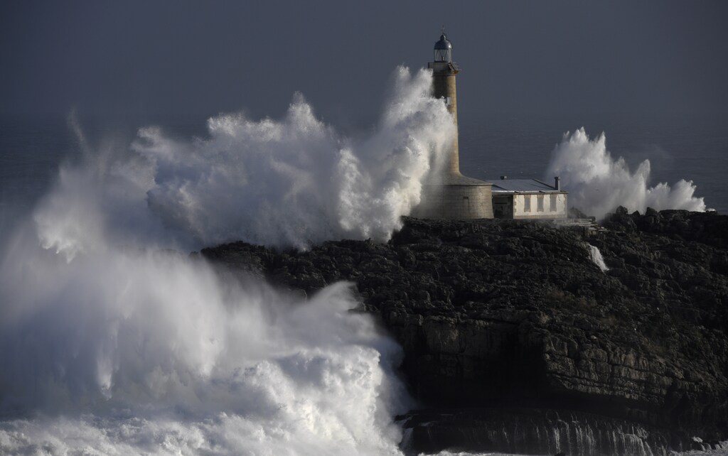Waves crash on the lighthouse of "La Isla del Mouro" in the port town of Santander in Spain, January 17, 2018.
