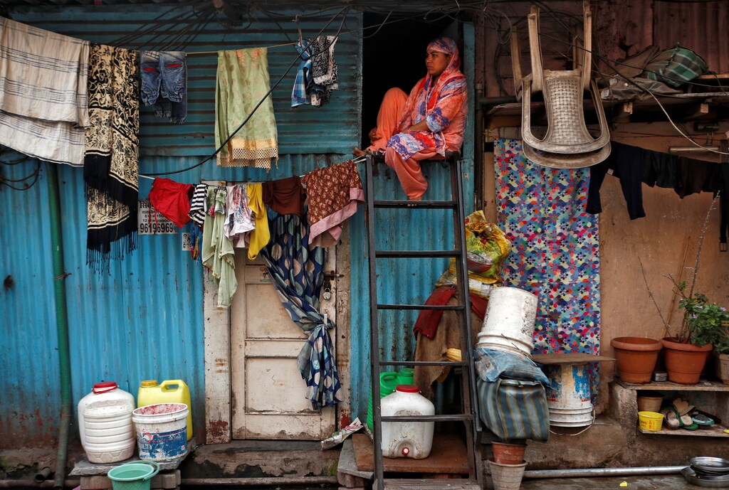 A woman sits on a ladder installed outside her house, during a nationwide lockdown in India to slow the spread of COVID-19, in Dharavi, one of Asia's largest slums, during the coronavirus disease outbreak, in Mumbai, India, April 13, 2020. REUTERS/Francis Mascarenhas SEARCH "CORONAVIRUS MUMBAI SLUM" FOR THIS STORY. SEARCH "WIDER IMAGE" FOR ALL STORIES. - RC2Z7G96ATBG