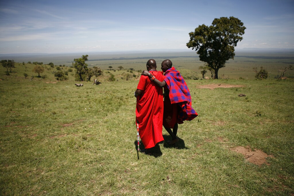 Two Maasai men walk outside Enkereri village near Masai Mara Game Reserve April 3, 2008.A rocky cliff overlooking the Reserve marks a new front line in a conflict between people and wildlife that threatens the revival of Kenya's $1 billion tourism industry. Riots and ethnic violence that exploded after a disputed December 27 vote scared away almost all the foreign holidaymakers. The disappearance of tourist dollars has disturbed the delicate balance between predators in the reserve and the Maasai tribesmen living next to it, by causing the breakdown of a compensation scheme meant to stop them hunting lions. Picture taken April 3, 2008. To match feature KENYA-WILDLIFE/ REUTERS/Radu Sigheti (KENYA ENVIRONMENT TRAVEL POLITICS) BEST QUALITY AVAILABLE - GM1E57T1ECV01