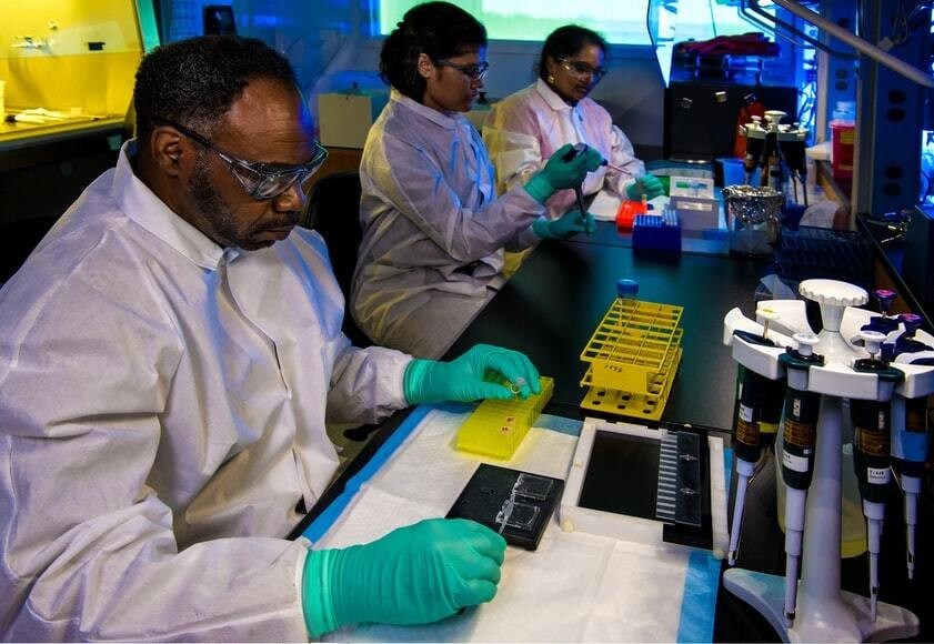 Public health scientist in a white coat developing samples in a laboratory.