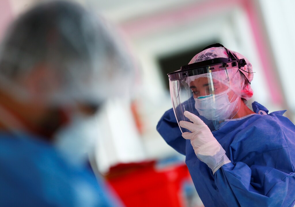 Kinesiologist Maria Luz Porra puts on a mask shield before checking patients suffering from the coronavirus disease (COVID-19) in an intensive care unit of a hospital, on the outskirts of Buenos Aires, Argentina October 16, 2020. Picture taken October 16, 2020.