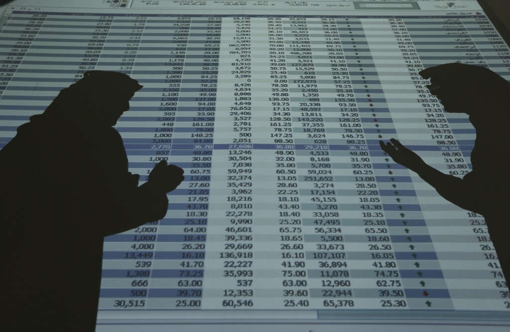 The shadows of investors and speculators are seen cast on a screen as they monitor stock prices at the FALCOM investment bank in Riyadh August 5, 2014. REUTERS/Faisal Al Nasser/File Photo - RTX2CKK6