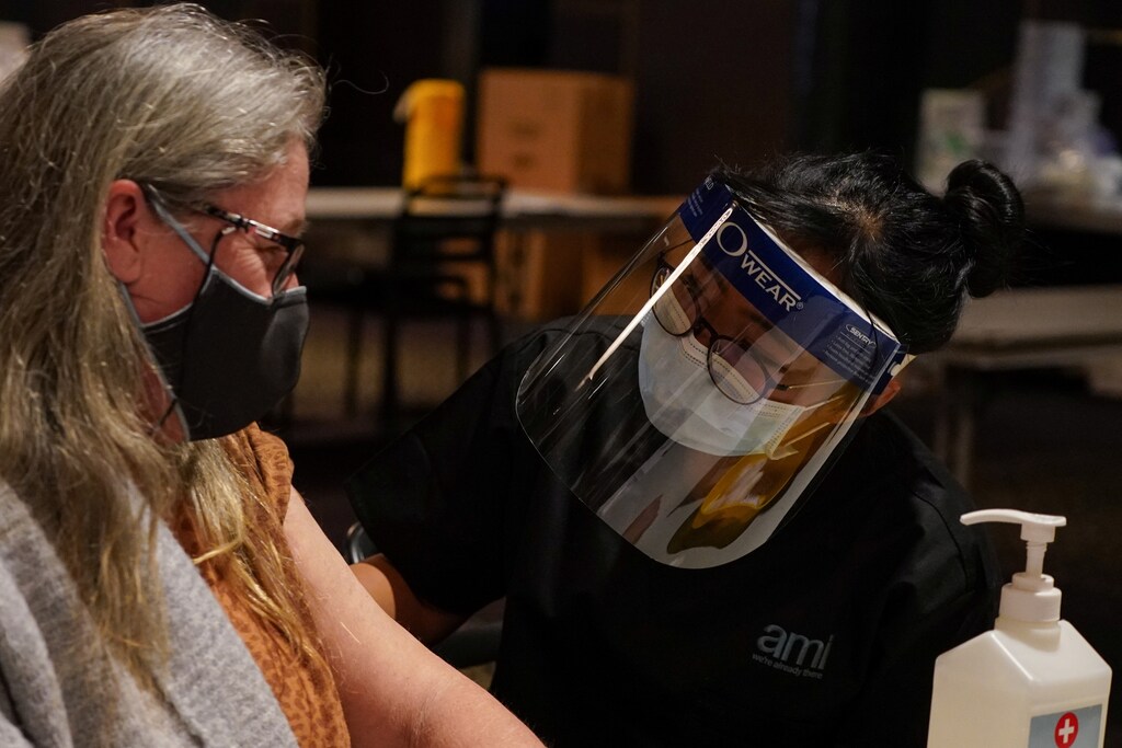 Nurse immuniser Selena De Leon speaks with patient Karen Brooks after administering the AstraZeneca vaccine at a coronavirus disease (COVID-19) vaccination clinic at the Bankstown Sports Club as the city experiences an extended lockdown, in Sydney, Australia