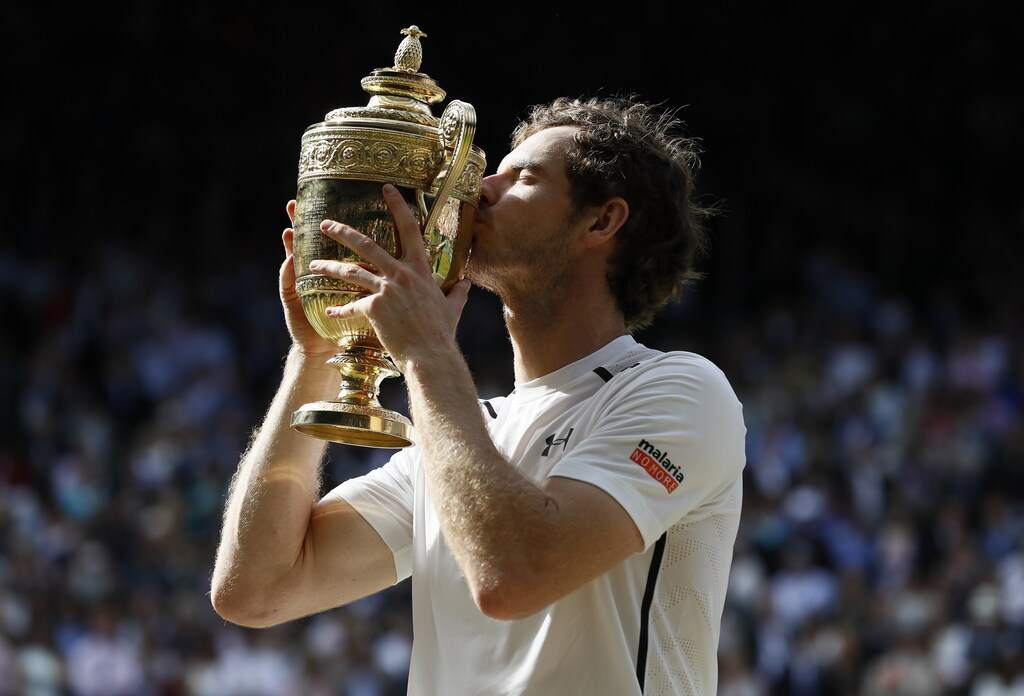 Britain Tennis - Wimbledon - All England Lawn Tennis & Croquet Club, Wimbledon, England - 10/7/16 Great Britain's Andy Murray kisses the trophy as he celebrates winning the mens singles final against Canada's Milos Raonic REUTERS/Stefan Wermuth - LR1EC7A1AA0JD