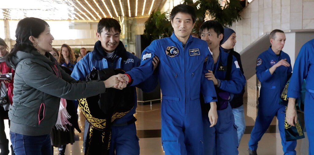 International Space Station (ISS) crew member Takuya Onishi of Japan is assisted by Japan Aerospace Exploration Agency (JAXA) specialists upon his arrival at the airport in Karaganda, Kazakhstan, October 30, 2016. REUTERS/Dmitri Lovetsky/Pool - RTX2R1VZ